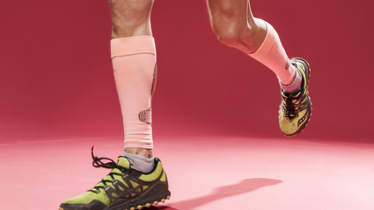 un homme court avec des baskets et des éléments de compression